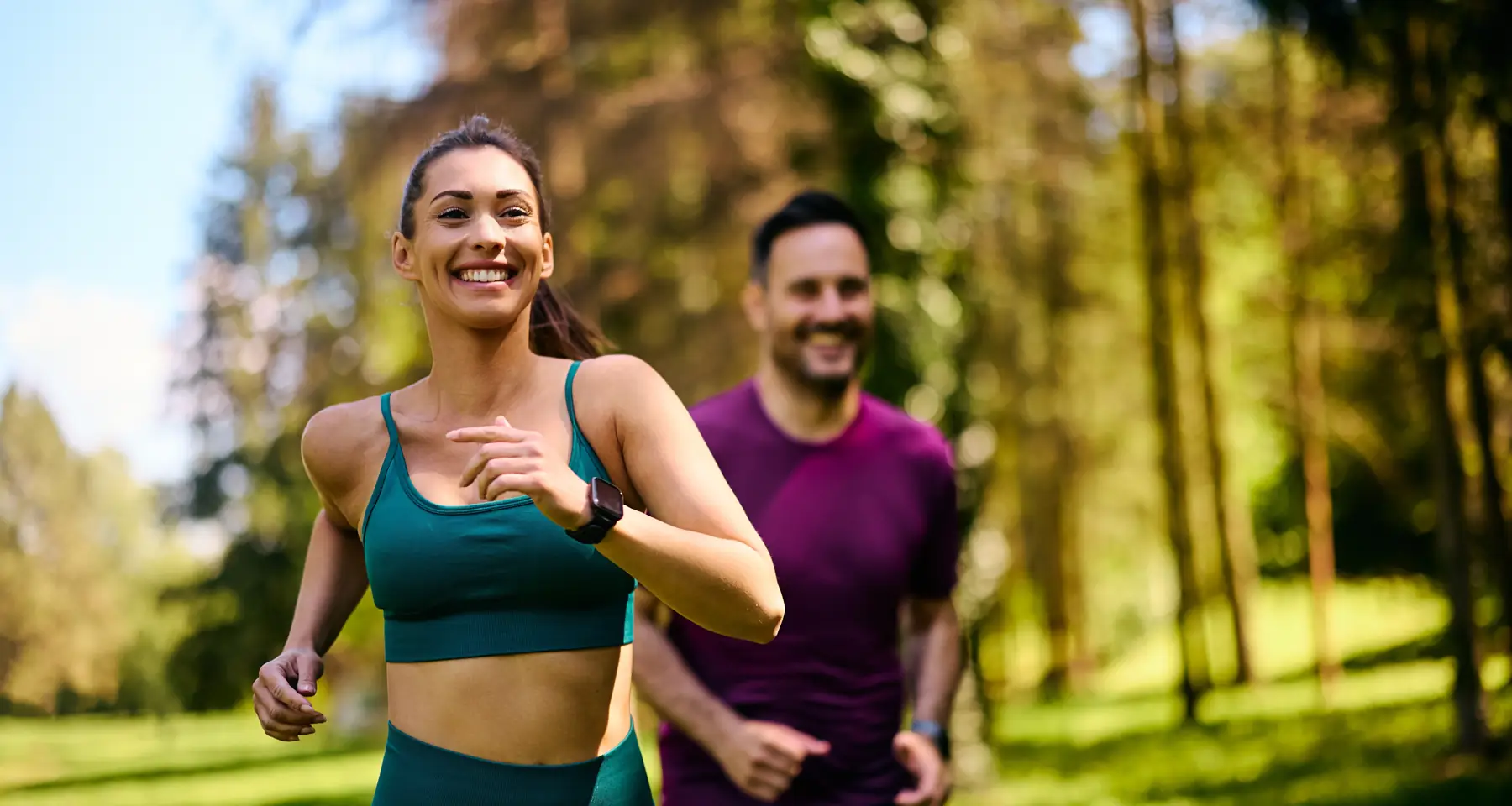A couple out running together through woodland
